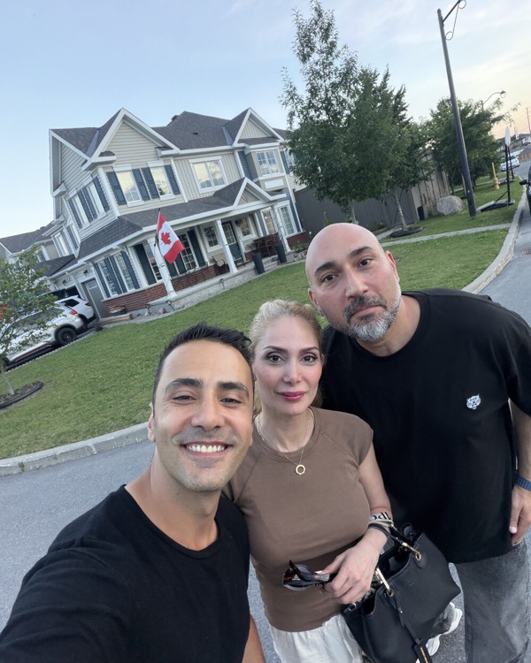 Mert with two of his buyers outside their new home