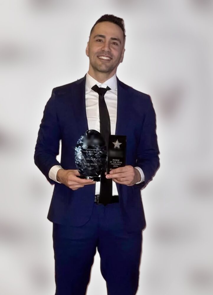 Mert Metin holding his 2024 Rookie of the Year and Outstanding Individual Sales awards