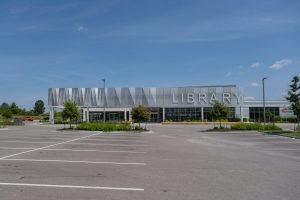 A modern library building in a suburban plaza setting, generic stand-in for the future Barrhaven facility