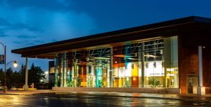 The Shenkman Arts Centre in Orléans at dusk, its coloured glass front lit up