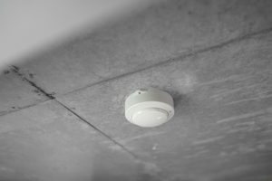 A round white alarm mounted on a ceiling